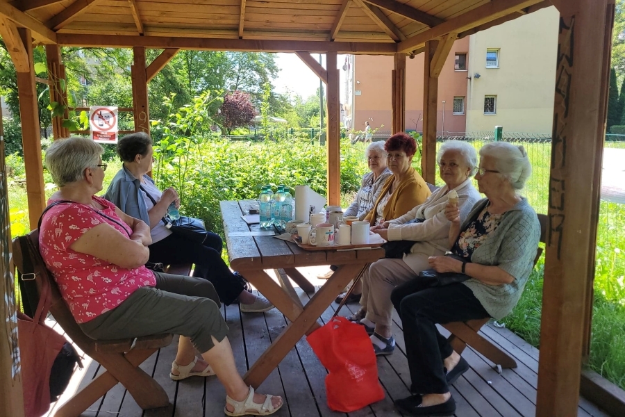 W altanie Ogrodu Społecznego siedzą seniorki z CAS, uczestniczki Pikniku Sąsiedzkiego