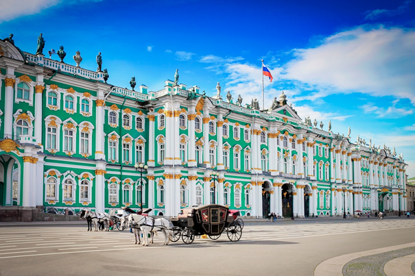 Pałac Zimowy w Sankt Petersburgu w Rosji. Widok na pałac, w którym znajduje się muzeum Ermitaż, obok stoi dorożka z koniem. Nad budynkiem powiewa flaga Rosji