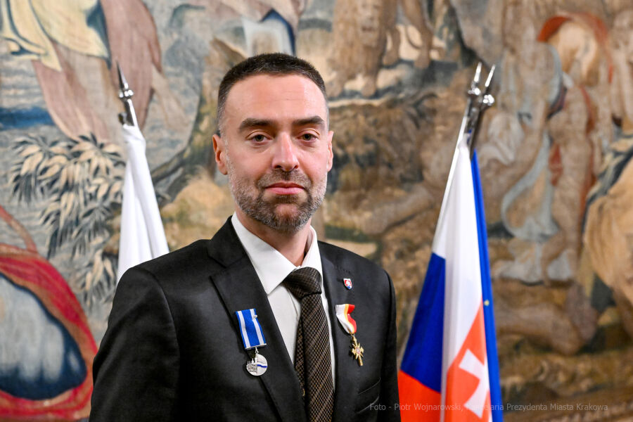 Konsul Generalny Słowacji na tle flag w sali Senatorskiej 