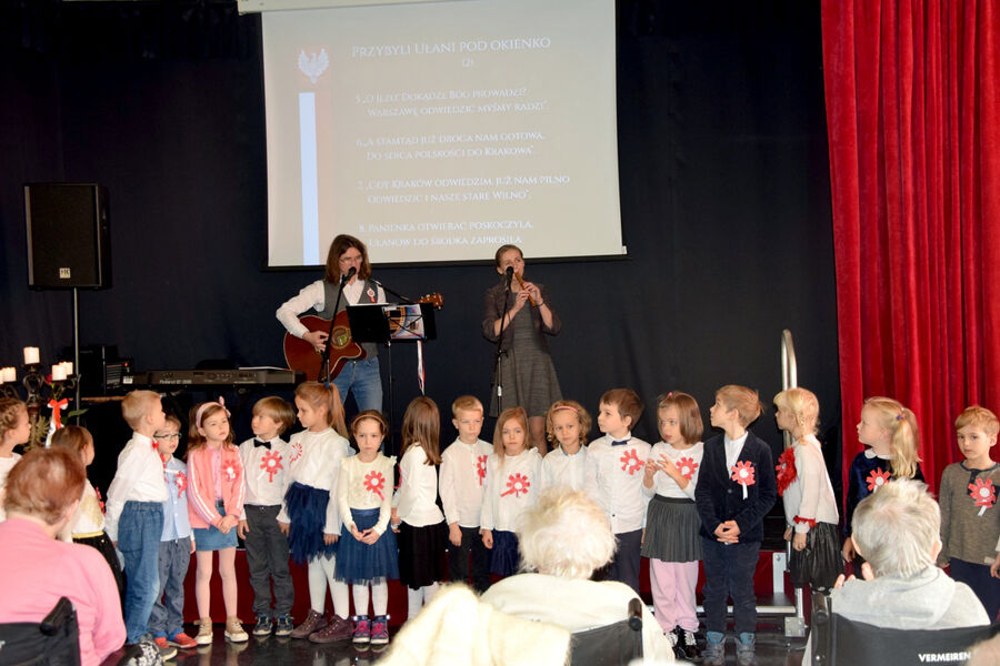 Na zdjęciu osiemnaścioro dzieci przedszkolnych oraz dwójka muzykujących instruktorów, pracowników Domu.  