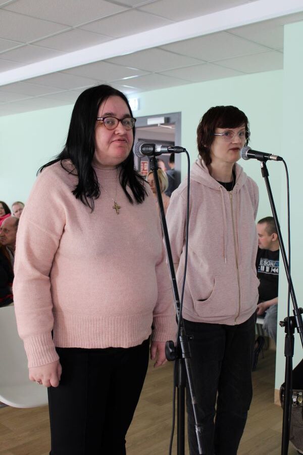 Dwie kobiety stojące przy mikrofonie.