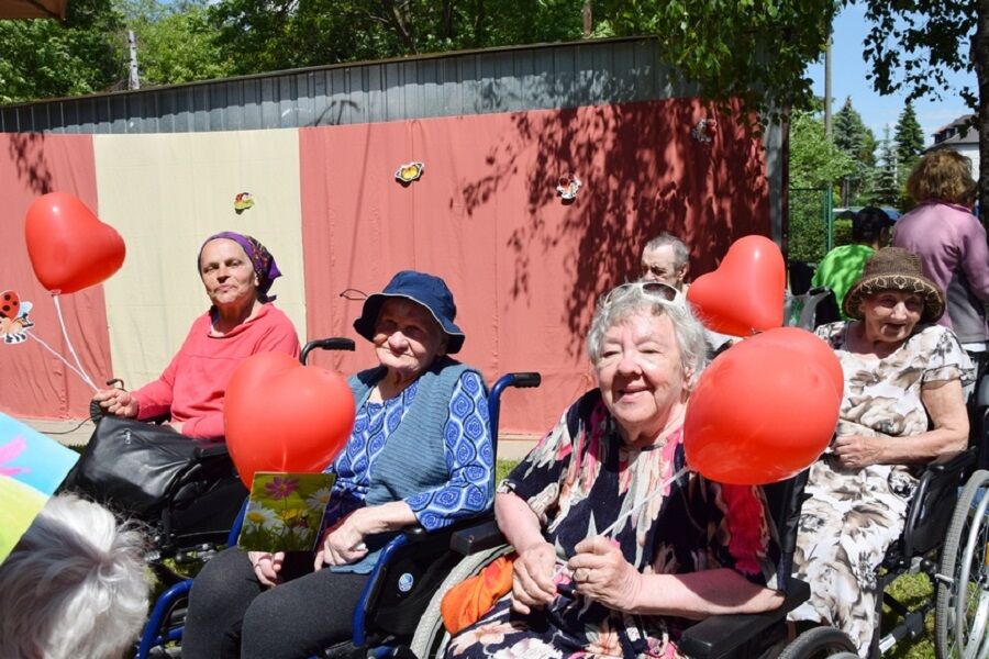 Uśmiechnięte Mieszkanki, uczestniczki pikniku trzymające w dłoniach balony w kształcie         serca.
