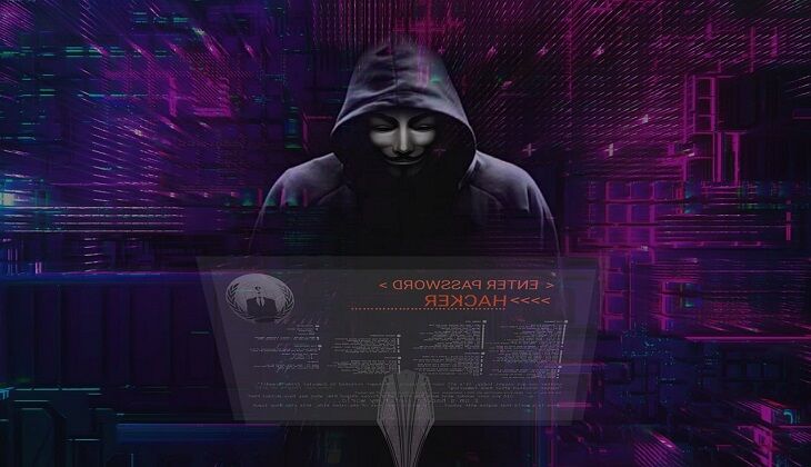 Grafika przedstawia postać hakera siedzącego przez komputerem