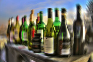 Zdjęcie przedstawia odpowiednio zniekształcone butelki kojarzące się z alkoholem.. Fot. krakow.pl