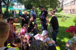 Policjant i dwóch Strażników Miejskich przeprowadza szkolenie z zasad bezpieczeństwa dla dzieci