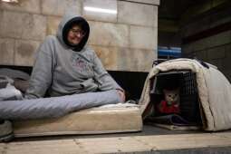 Kobieta ukrywa się przed ostrzałem ze swoim kotem w metrze