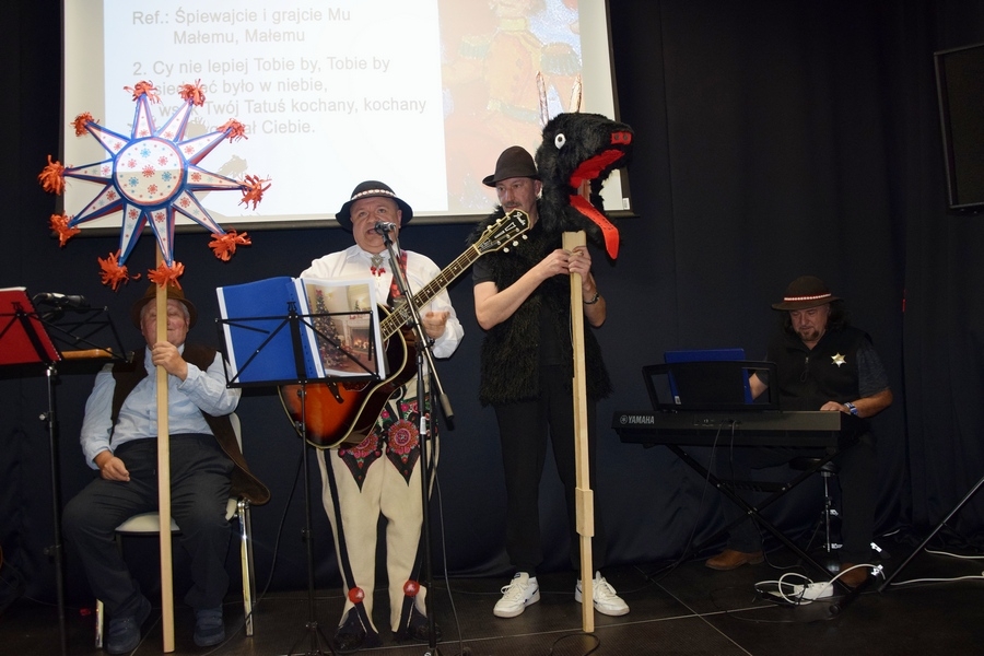 Trzech kolędników góral grający na gitarze, dwóch pastuszków, z których jeden z turoniem drugi z gwiazdą podczas występu.
