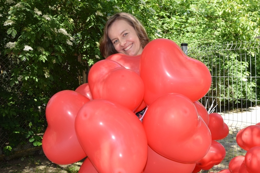 Uśmiechnięta instruktorka zajęć terapeutycznych z balonami w kształcie serca