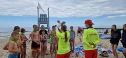 dzieci stoją na plaży z ratownikami