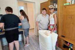 dwie uśmiechnięte kobiety stoją i trzymają materac