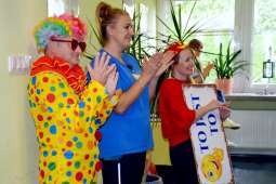 Uśmiechnięci pracownicy Domu oklaskujący Mieszkańców prezentujących swój  program