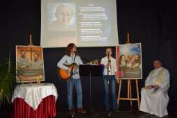 Kapelan oraz dwójka instruktorów prowadzących śpiew