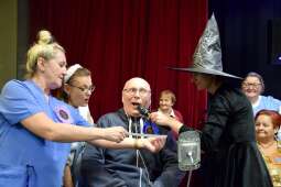 Jeden z mieszkańców wraz z opiekunem i prowadzącą w trakcie zabawy z wróżbami