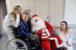 Mieszkaniec na wózku wraz z Mikołajem i dwoma aniołkami