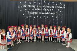 w rzędzie stoją dzieci w strojach krakowskich. trwa występ