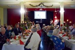 Mieszkańcy przy stole wigilijnym w sali terapii zajęciowej