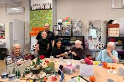 Na zdjęciu Pan Grzegorz z Panią Magdą Matykiewicz oraz córką Gabrysią wraz z Mieszkankami w pracowni terapii zajęciowej. 