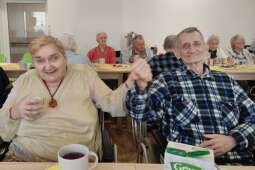 Na zdjęciu Mieszkanka wraz z Mieszkańcem siedząc na wózkach zaczęli tańczyć do dźwięków muzyki. 