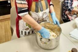 Na zdjęciu Mieszkanka wyrabia ciasto w garnku podczas zajęć kulinarnych – rogaliki. 