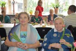 Dwie Mieszkanki z kwiatami w dłoniach