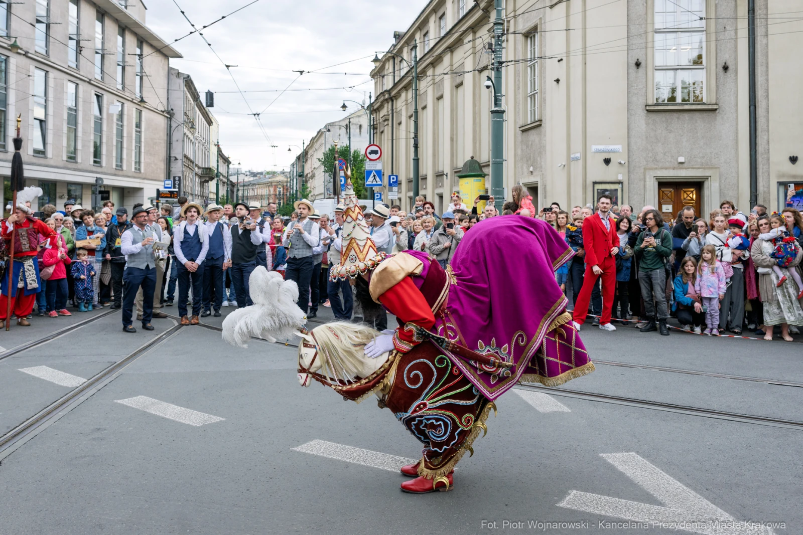 Tancerz w tradycyjnym stroju wykonujący taniec na ulicy, otoczony przez widownię.  Autor: Piotr Wojnarowski