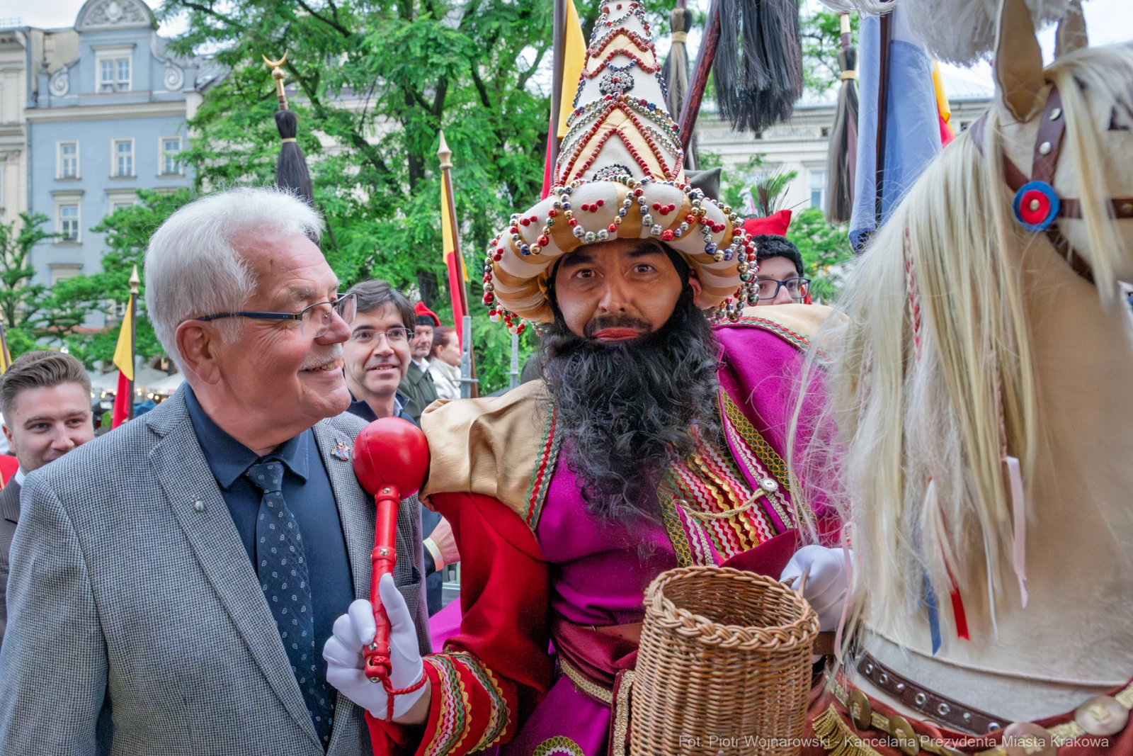 Mężczyzna w kolorowym stroju z koszem i berłem, obok niego inny mężczyzna w garniturze.  Autor: Piotr Wojnarowski