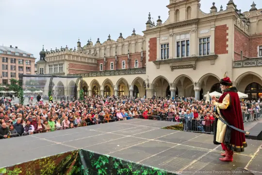 Mężczyzna w historycznym stroju przemawia do tłumu na rynku w Krakowie.
