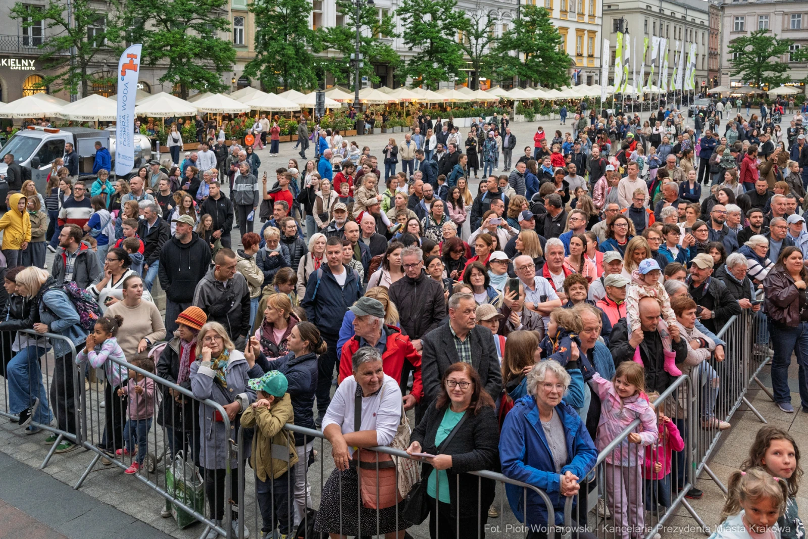Tłum ludzi zgromadzony na placu, z widocznymi straganami i drzewami w tle.  Autor: Piotr Wojnarowski
