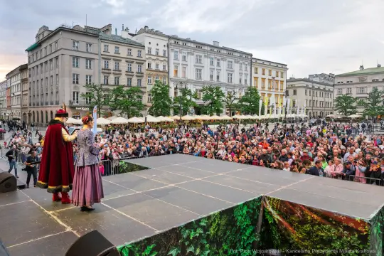 Tłum ludzi na placu, występujący zespół w tradycyjnych strojach.