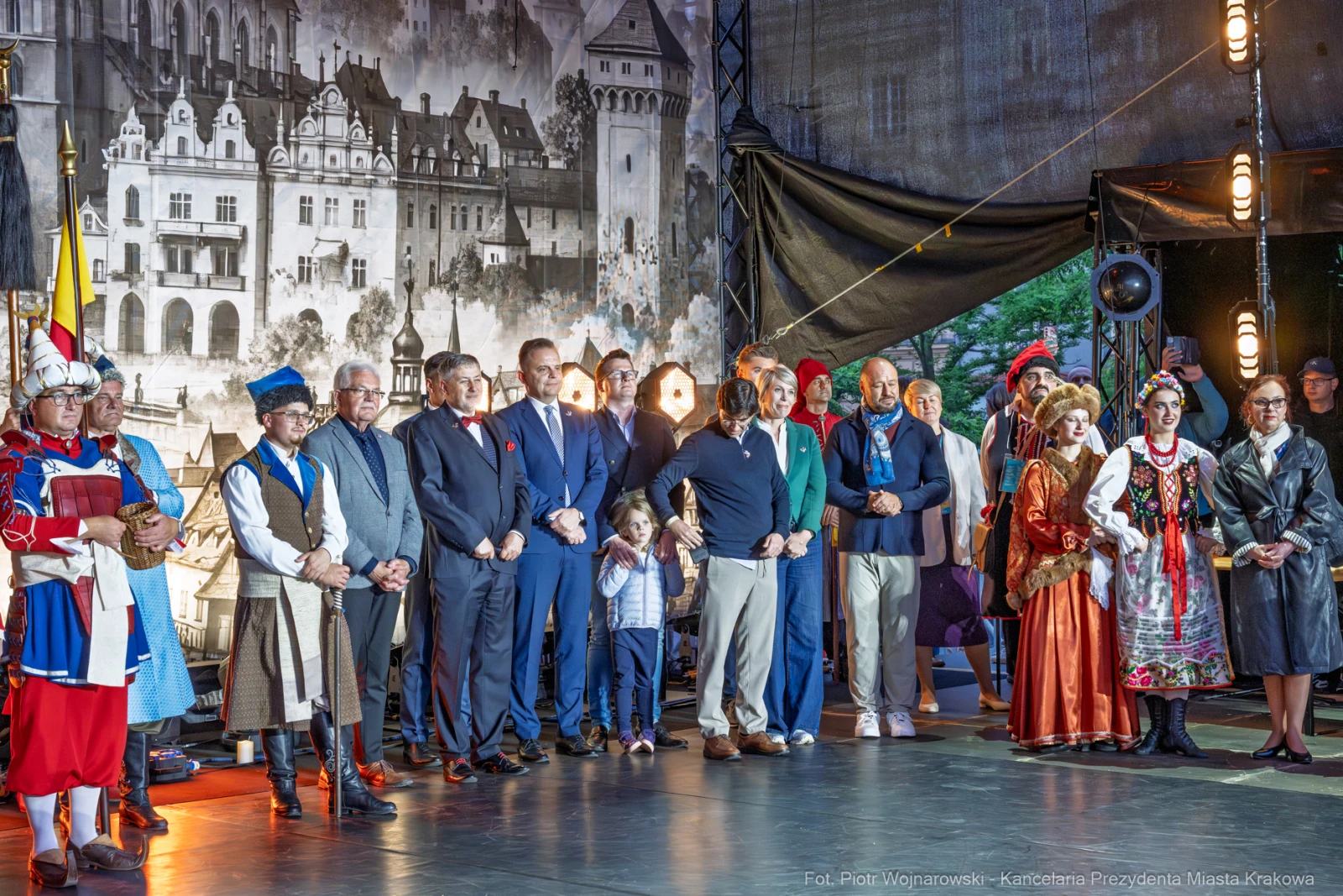 Grupa osób w tradycyjnych strojach, stojących na scenie podczas wydarzenia kulturalnego.  Autor: Piotr Wojnarowski