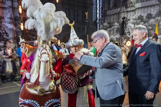 Uczestnicy wydarzenia w tradycyjnych strojach, z końmi i rekwizytami.