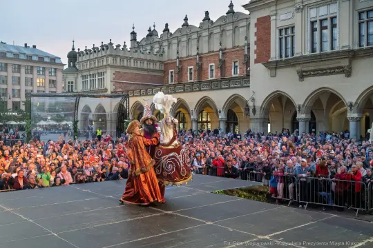 Tłum ludzi na rynku, występ artystyczny w tradycyjnych strojach.