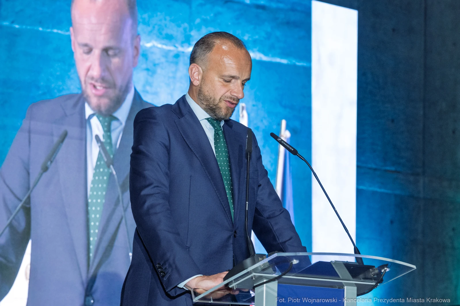 Mężczyzna w garniturze przemawia z mównicy podczas wydarzenia.  Autor: Piotr Wojnarowski
