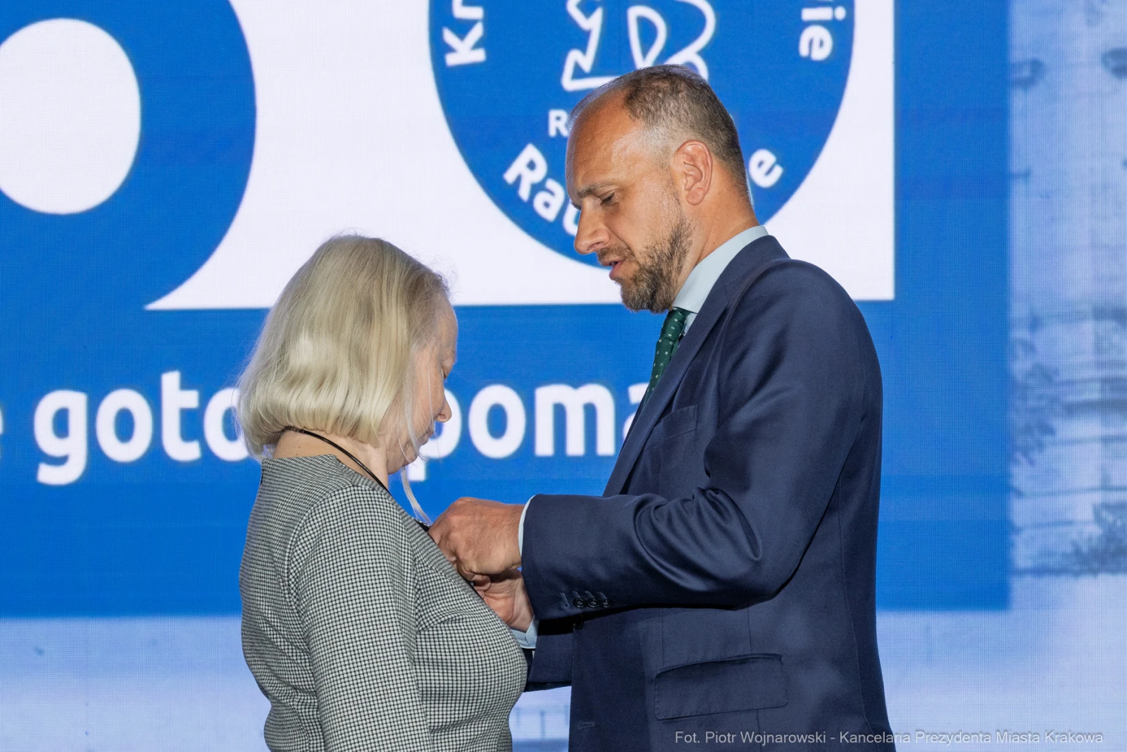 Wręczenie odznaczenia przez mężczyznę kobiecie podczas ceremonii.  Autor: Piotr Wojnarowski