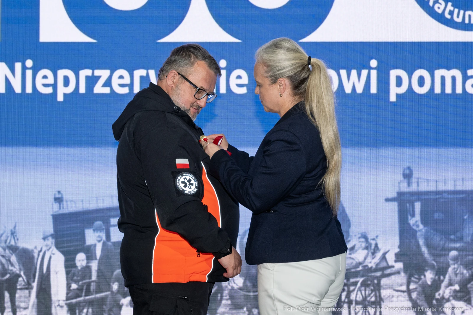 Mężczyzna w mundurze otrzymuje medal od kobiety w garniturze.  Autor: Piotr Wojnarowski