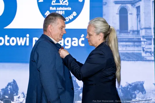Wręczenie odznaczenia przez kobietę mężczyźnie podczas uroczystości.