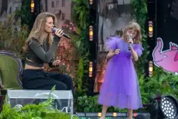 Kobieta i dziewczynka śpiewają na scenie, obie trzymają mikrofony.