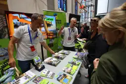 Stoiska promocyjne z materiałami informacyjnymi i rozmowy z odwiedzającymi.