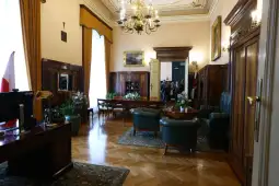 Eleganckie wnętrze z drewnianymi meblami, roślinami i dużymi oknami.