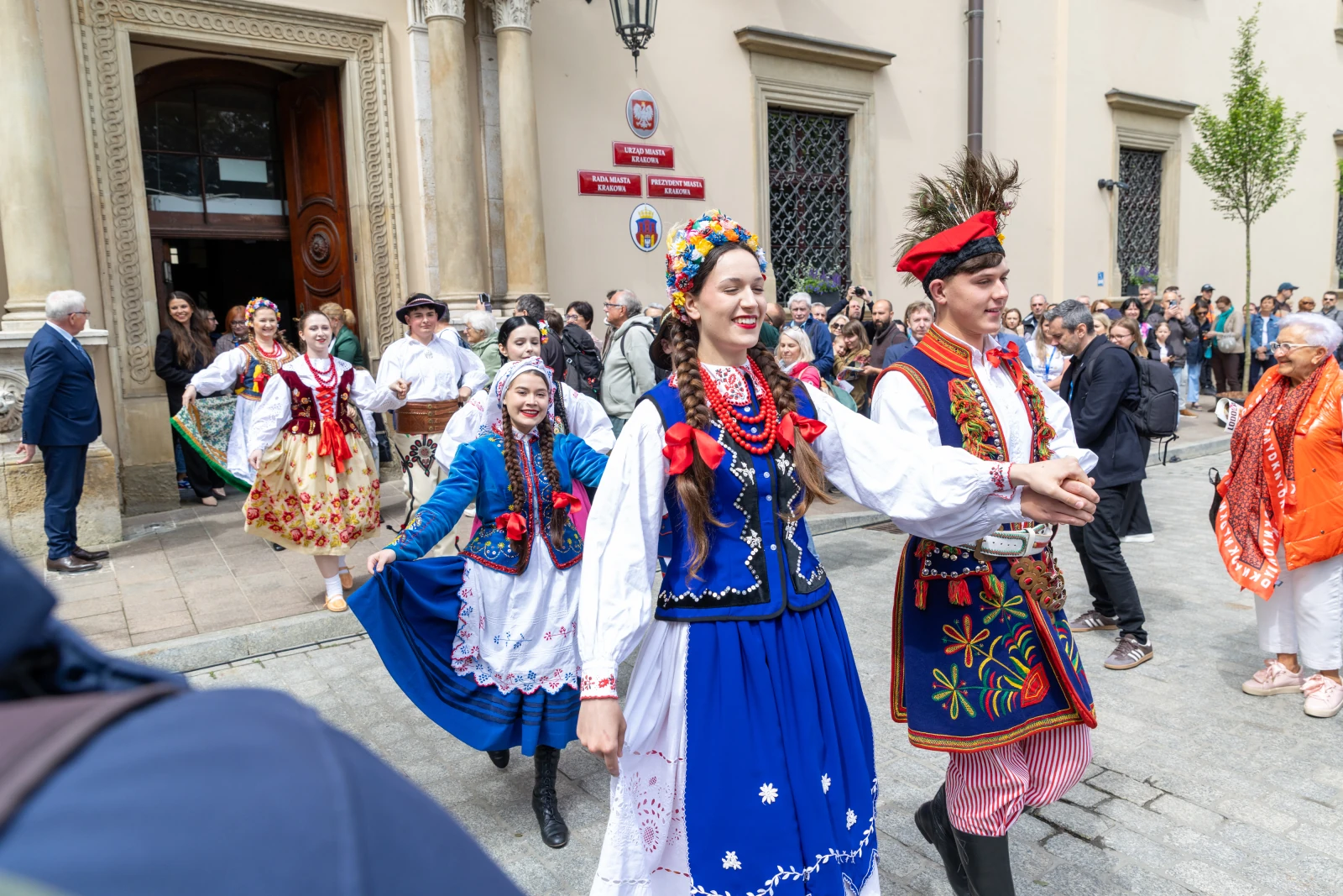 Grupa osób w tradycyjnych strojach ludowych tańczy na ulicy podczas festiwalu.  Autor: Bogusław Świerzowski