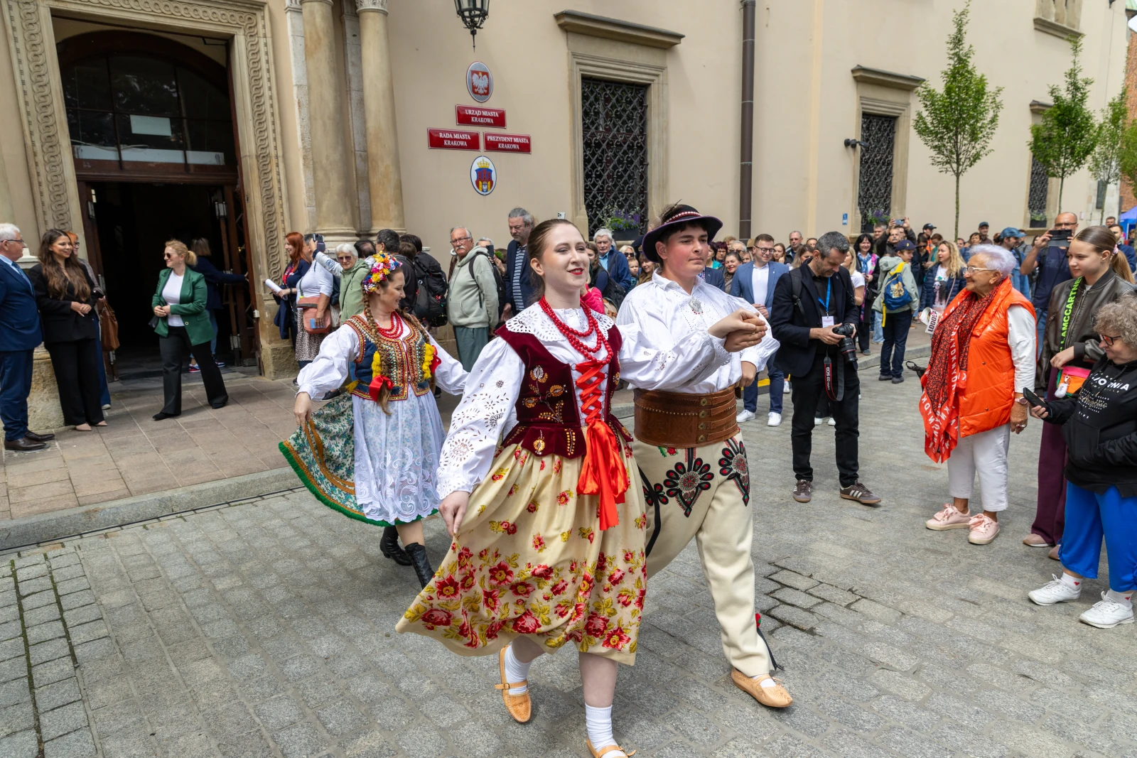 Tradycyjny taniec ludowy w strojach regionalnych na ulicy, z uczestnikami i widzami.  Autor: Bogusław Świerzowski