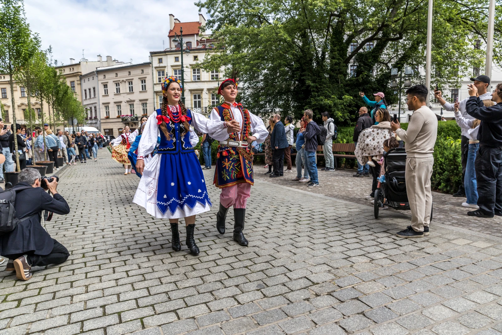 Para w tradycyjnych strojach ludowych tańczy na ulicy, otoczona widzami.  Autor: Bogusław Świerzowski