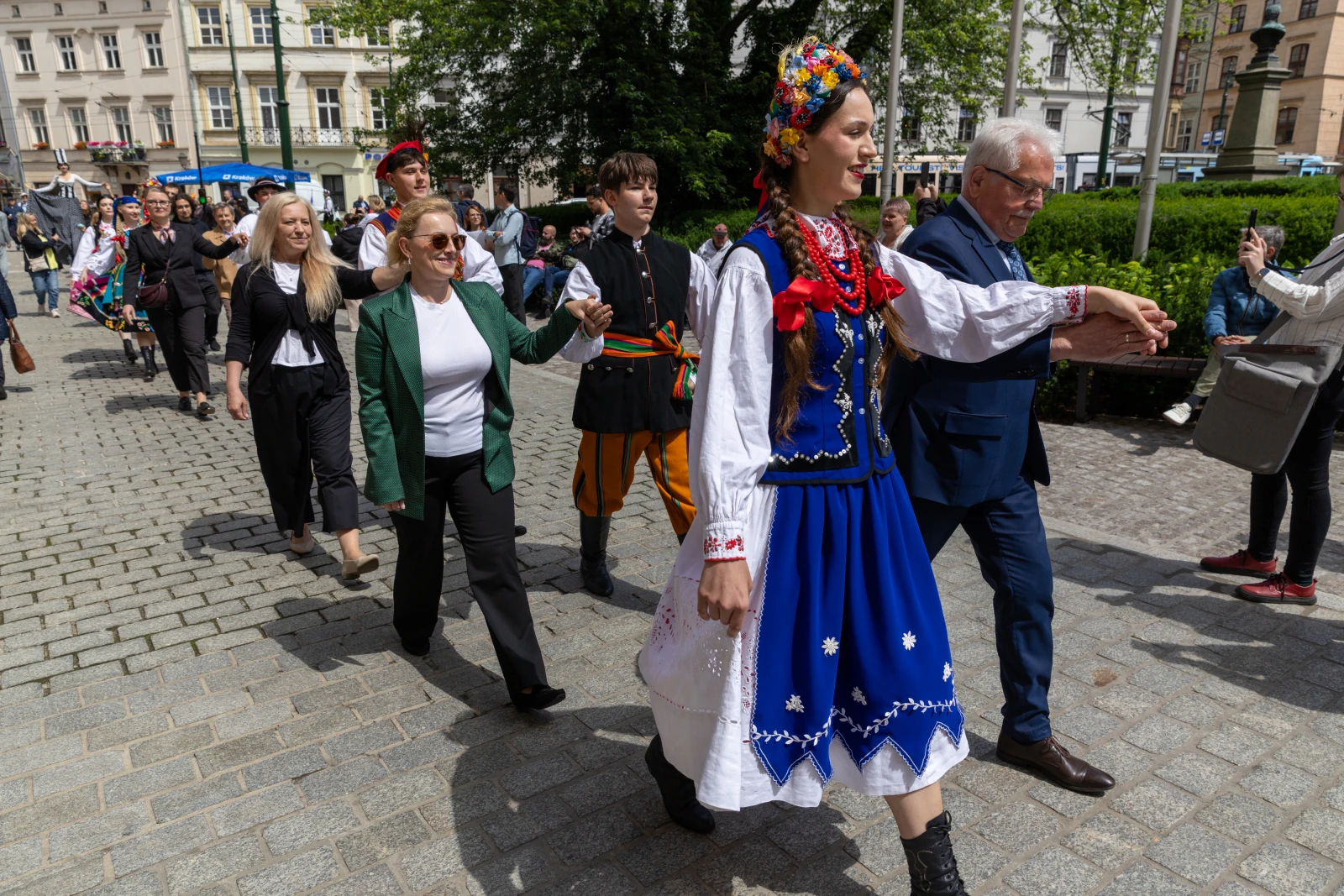 Grupa ludzi w tradycyjnych strojach ludowych podczas parady.  Autor: Bogusław Świerzowski