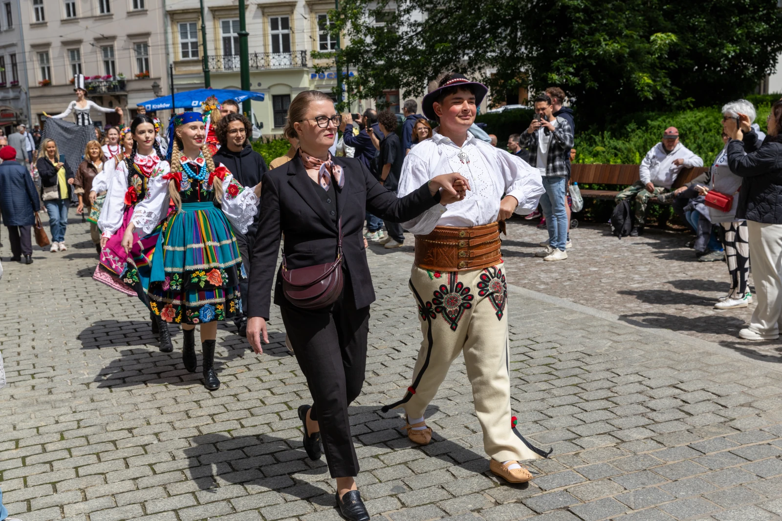 Grupa osób w tradycyjnych strojach ludowych idzie ulicą podczas festiwalu.  Autor: Bogusław Świerzowski