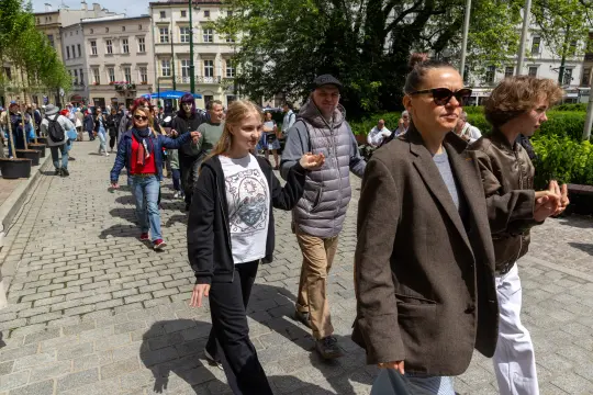 Grupa ludzi spacerujących po ulicy w mieście.