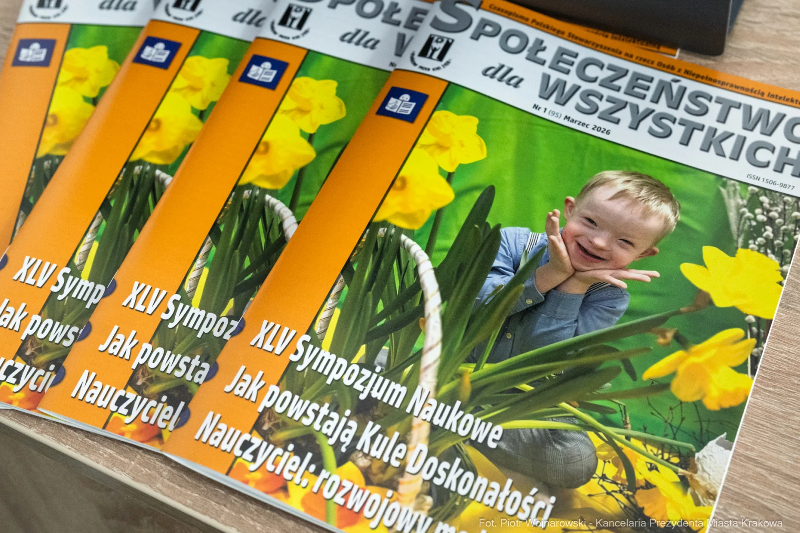 Chłopiec uśmiechający się wśród żółtych kwiatów, okładki czasopisma o tematyce edukacyjnej.  Autor: Piotr Wojnarowski