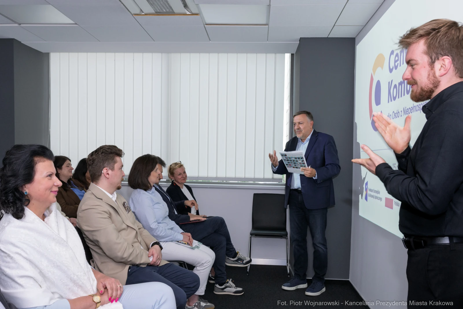 Spotkanie grupy ludzi z mężczyzną prezentującym informacje na ekranie.  Autor: Piotr Wojnarowski