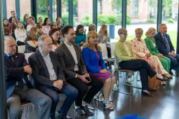 Grupa osób siedzących w sali podczas wydarzenia.