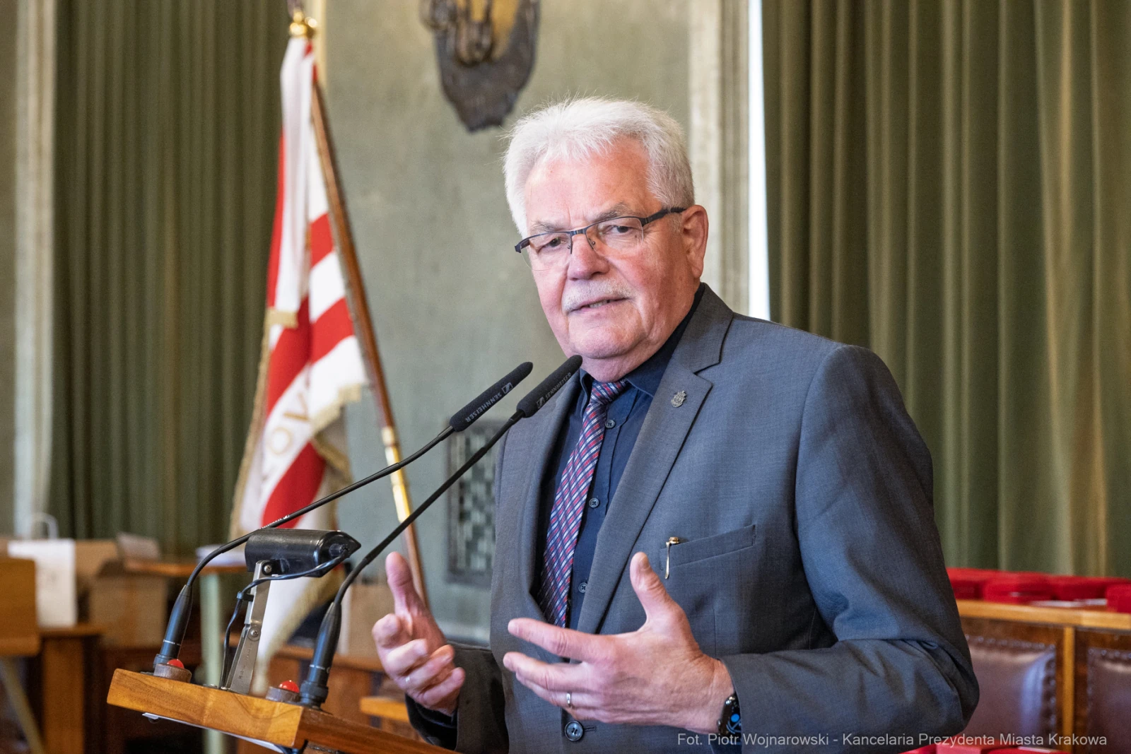 Mężczyzna w okularach przemawia przy mównicy w sali konferencyjnej.  Autor: Piotr Wojnarowski