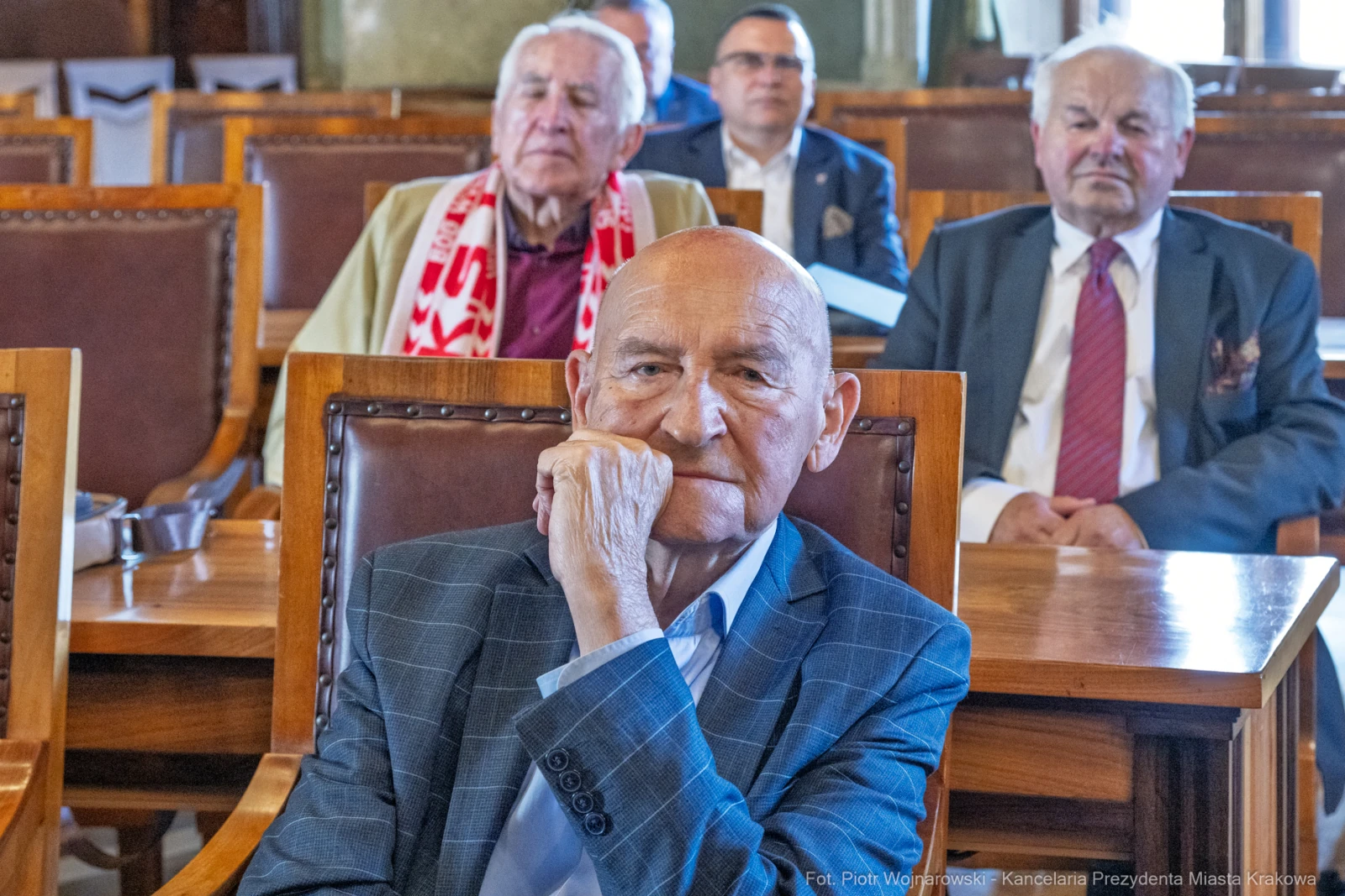 Mężczyzna w garniturze siedzi w sali, w tle inni uczestnicy spotkania.  Autor: Piotr Wojnarowski